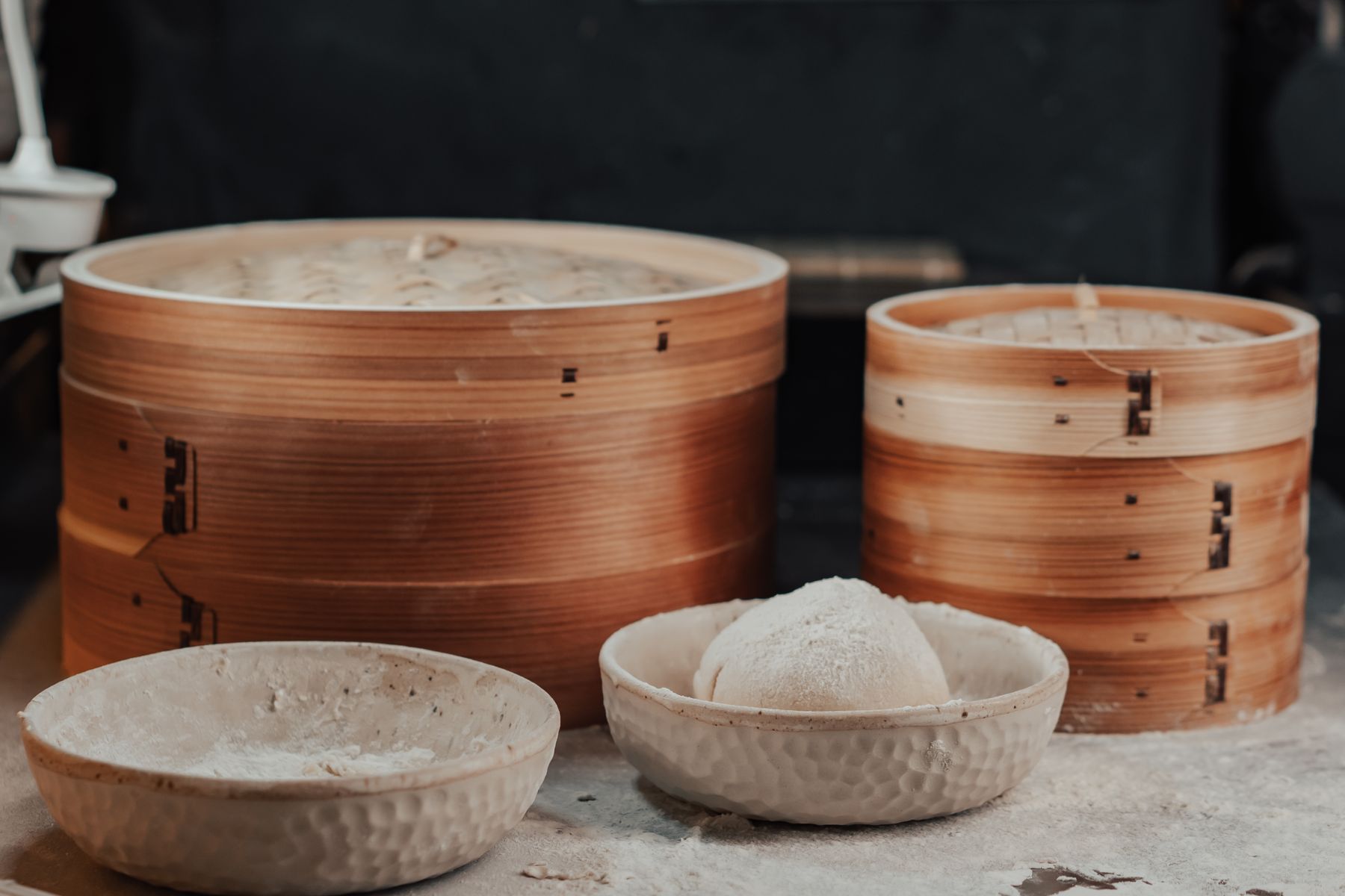 Vaporeras de bambú apiladas junto a un cuenco de arroz