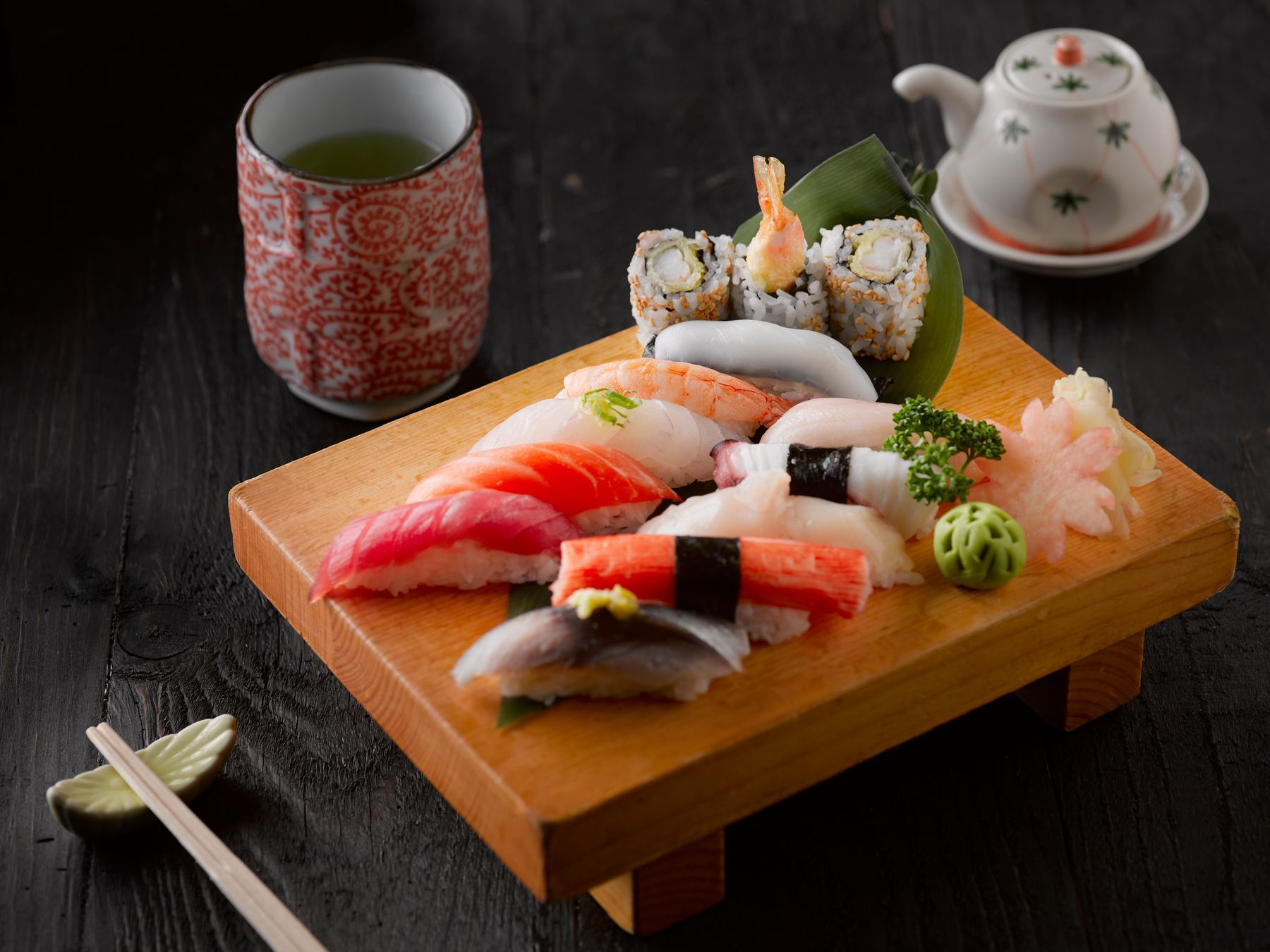 Sushi sobre tabla con taza de té