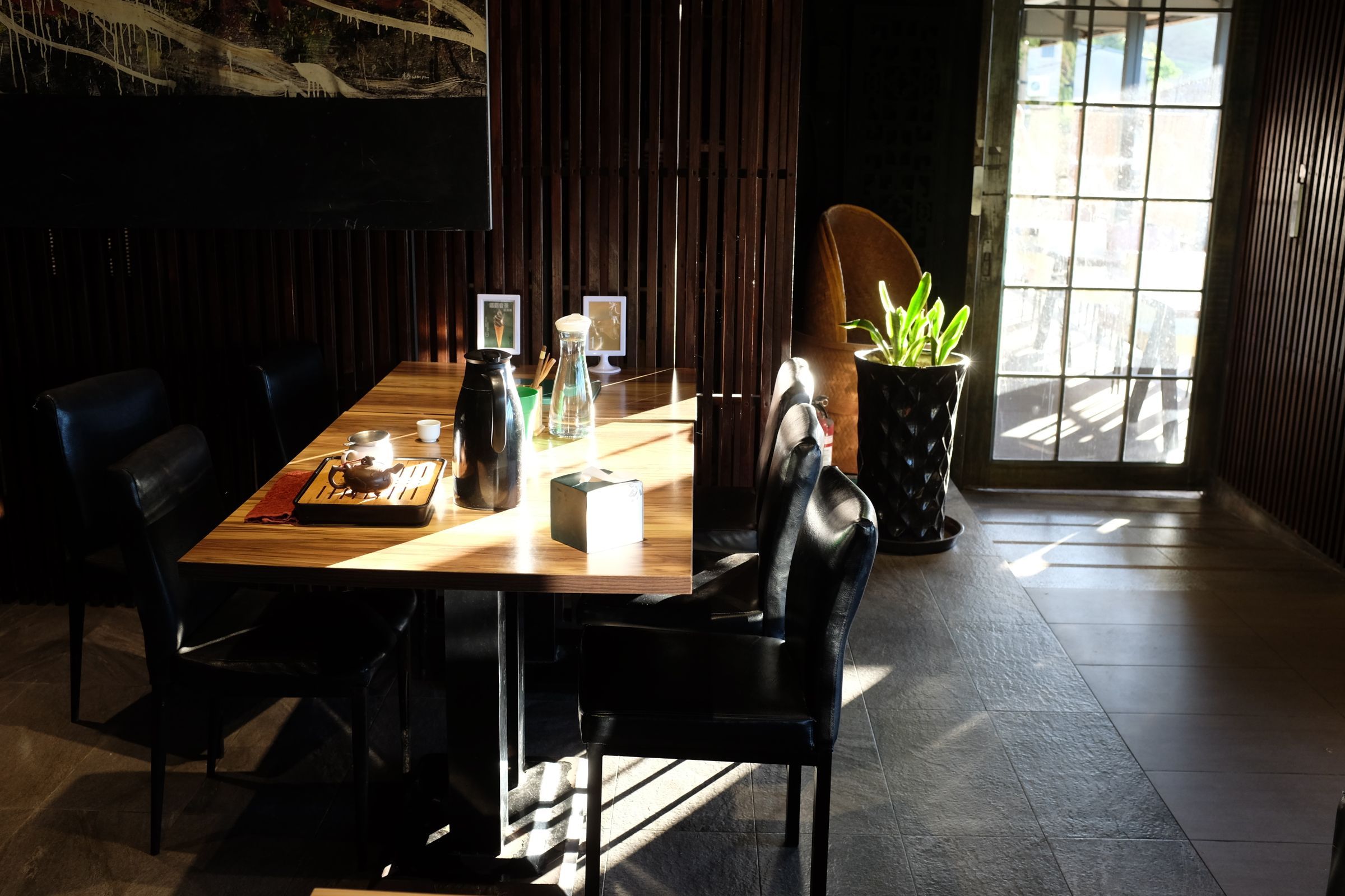 Sala de Mr. Chen en penumbra con un cerezo iluminado al fondo