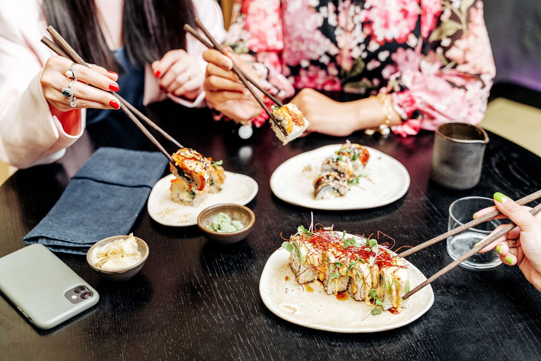 Mesa compartida con platos al centro y ramas de cerezo al fondo