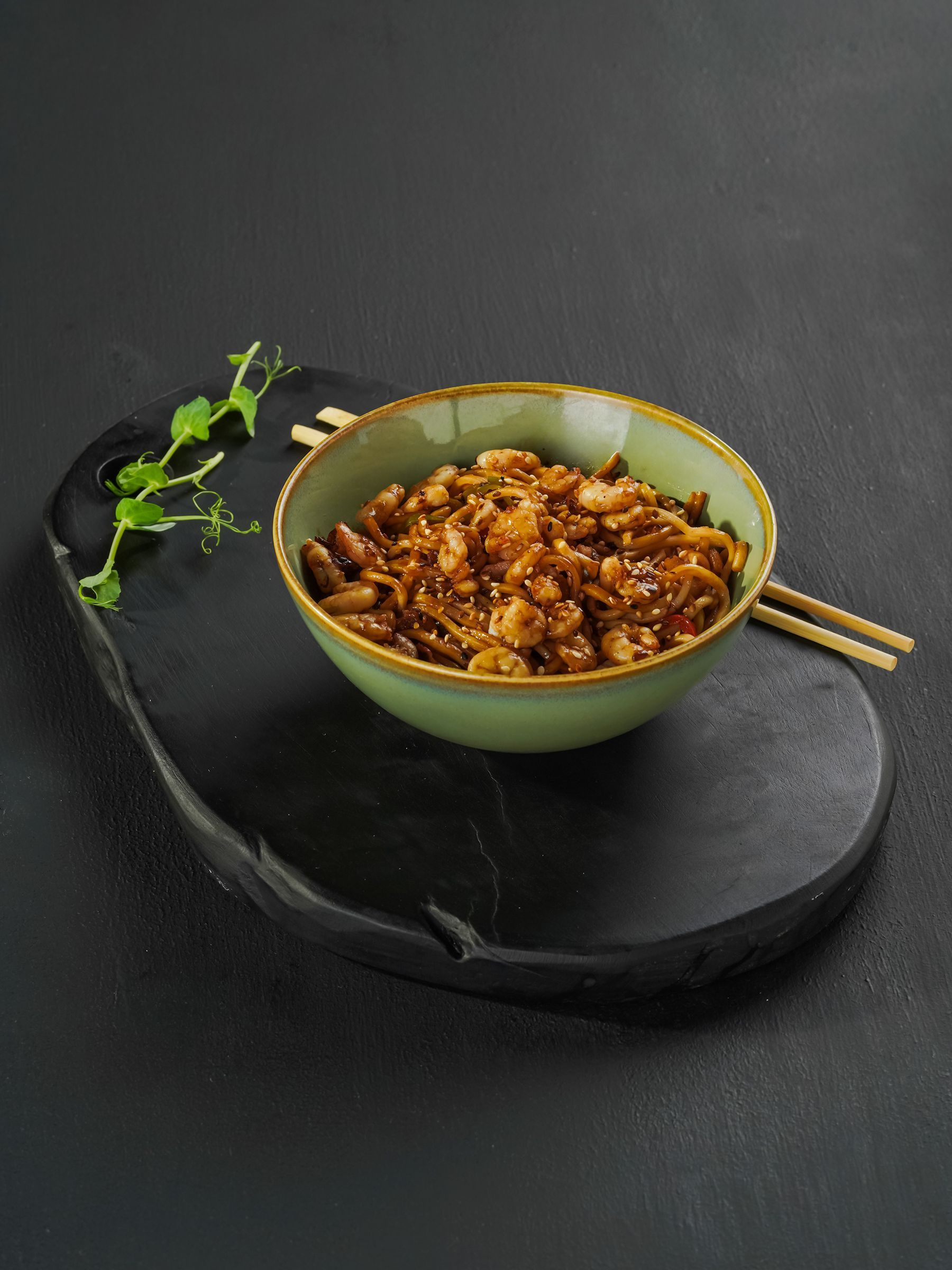 Yakisoba de pollo salteado servido en un cuenco verde